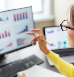 woman with glasess looking at data on screen