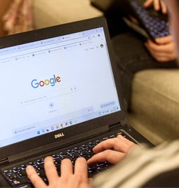 A man uses Google search on his laptop