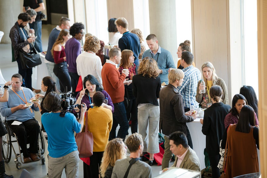 Event space full of a crowd of people networking and talking