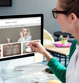 Woman and man pointing at a desktop screen while designing a website