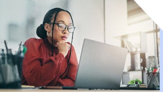 Woman sat and looking focused at the laptop in front of her