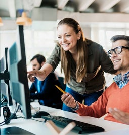 Man and woman work at same desktop screen