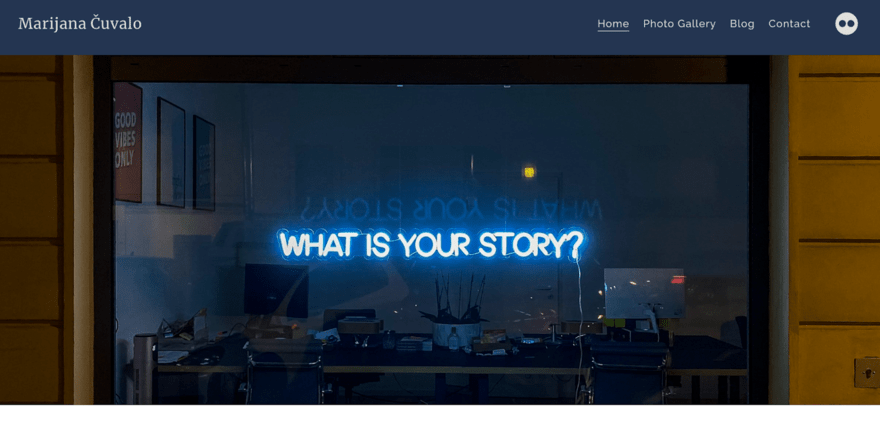 Neon sign asking "WHAT IS YOUR STORY?" visible through a window reflecting the night sky, adjacent to a yellow door.